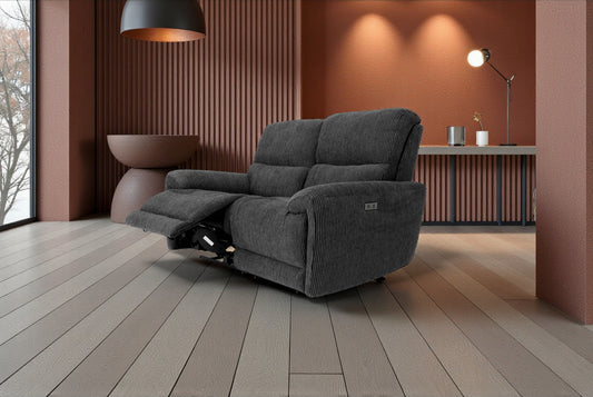 Gray recliner chair in a modern living room setting with wooden floor and wall.