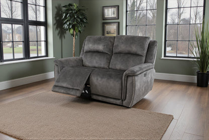 Gray recliner chair in a room with large windows and plants.
