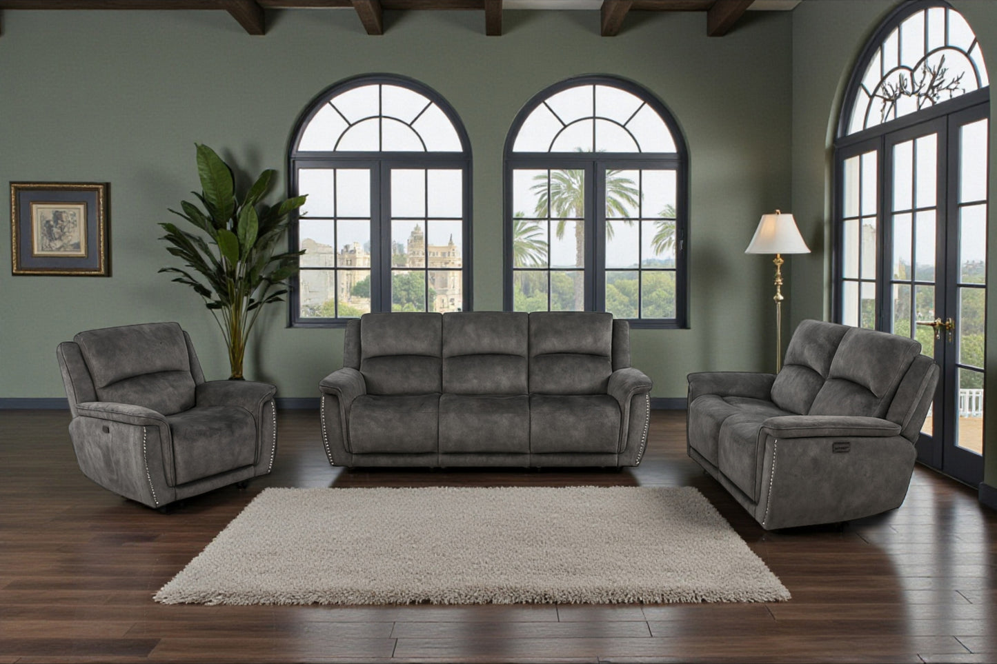 Gray sofa set in a living room with large windows and a rug.