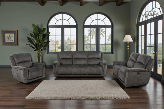 Gray sofa set in a living room with large windows and a rug.