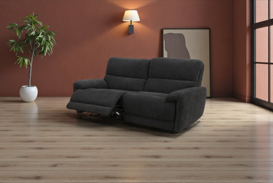 Gray sofa in a room with a plant and wall lamp.