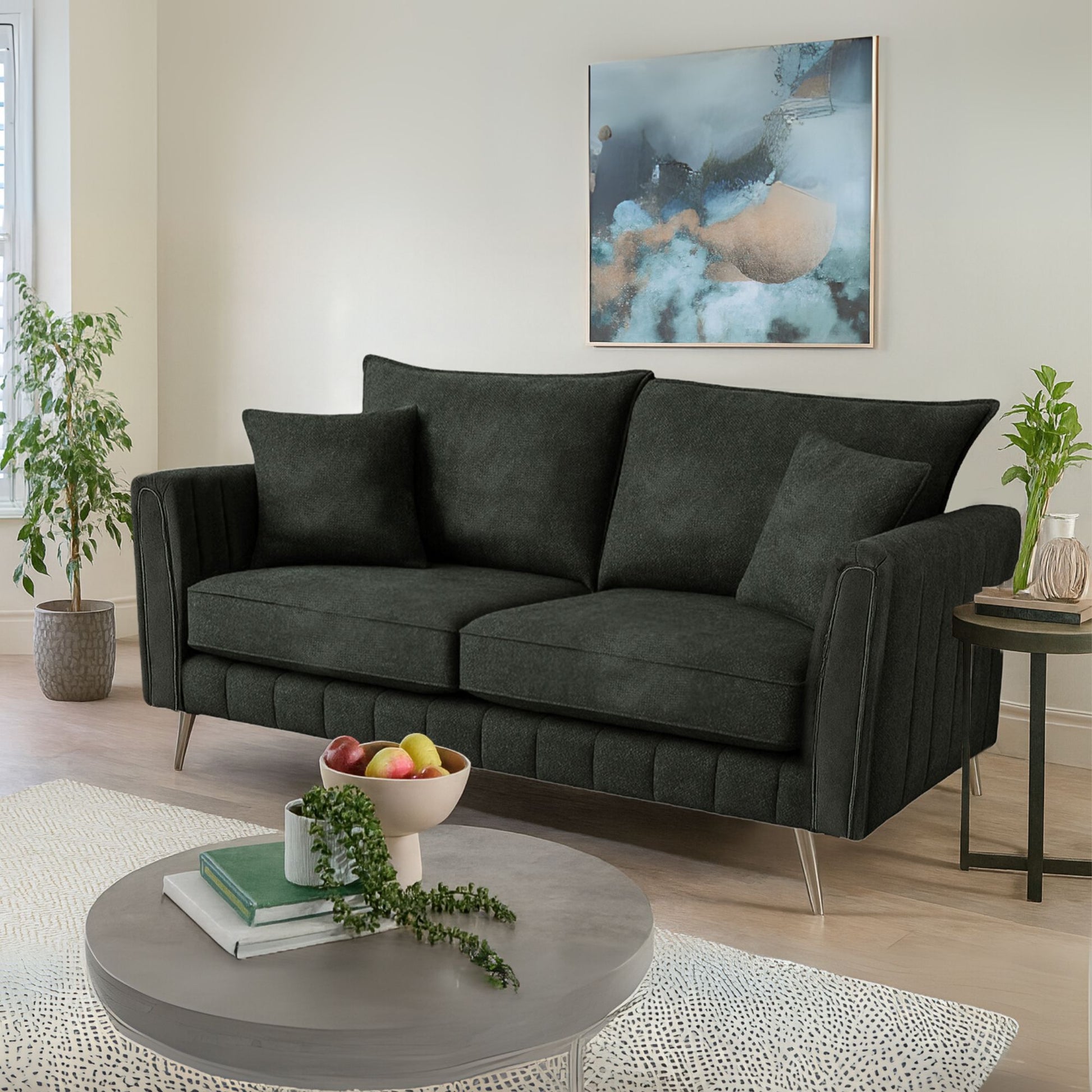 Modern living room with a dark gray sofa, round coffee table, and abstract art on the wall.