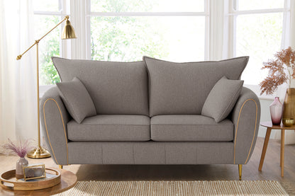 Gray sofa in a living room with a lamp and decor items.