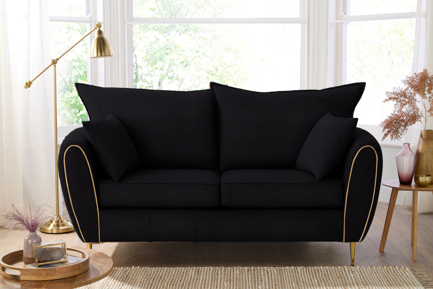 Black sofa with gold trim in a living room setting