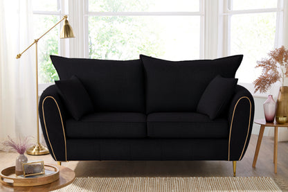 Black sofa with gold trim in a living room setting