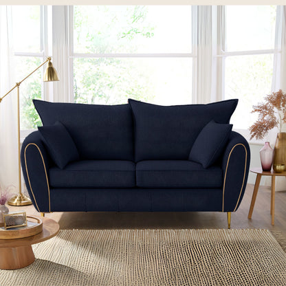 Navy blue sofa in a living room with large windows and decorative elements.