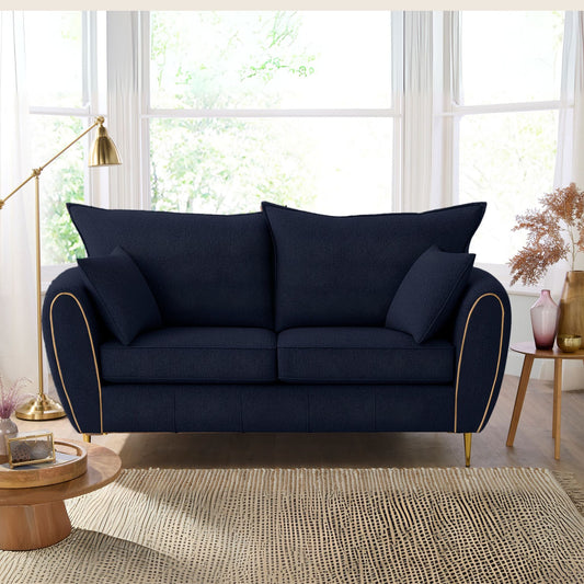 Navy blue sofa in a living room with large windows and decorative elements.