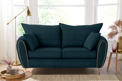 Teal sofa with decorative pillows in a bright living room setting