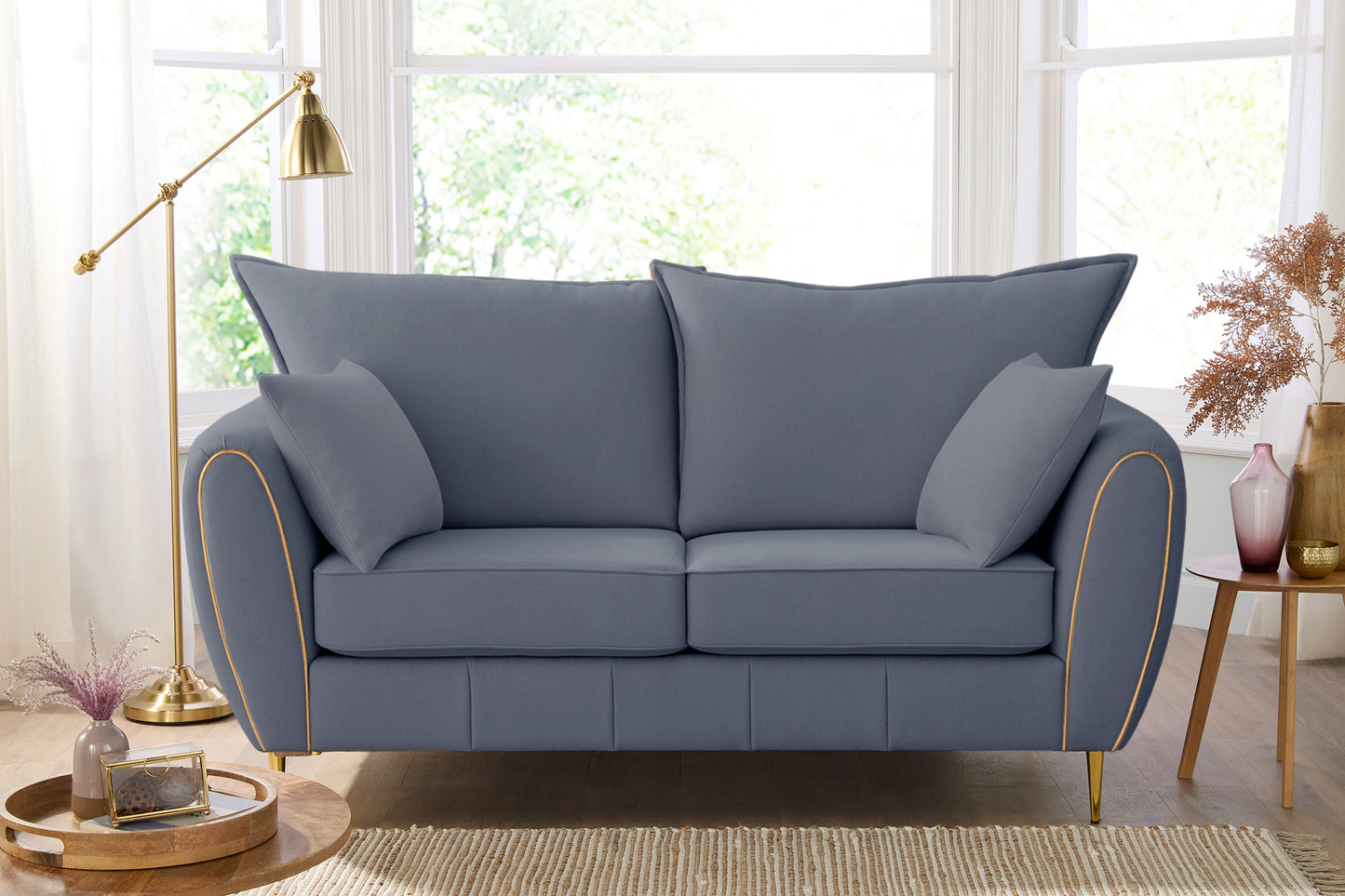 Gray sofa in a living room with a lamp and decor items.