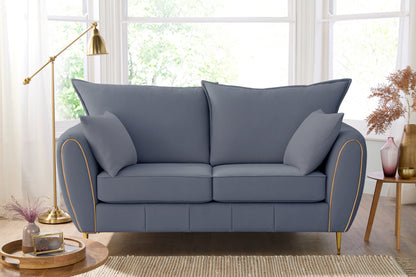 Gray sofa in a living room with a lamp and decor items.