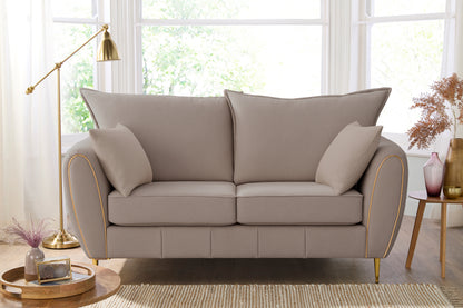 Beige sofa in a living room with a lamp and decor items.
