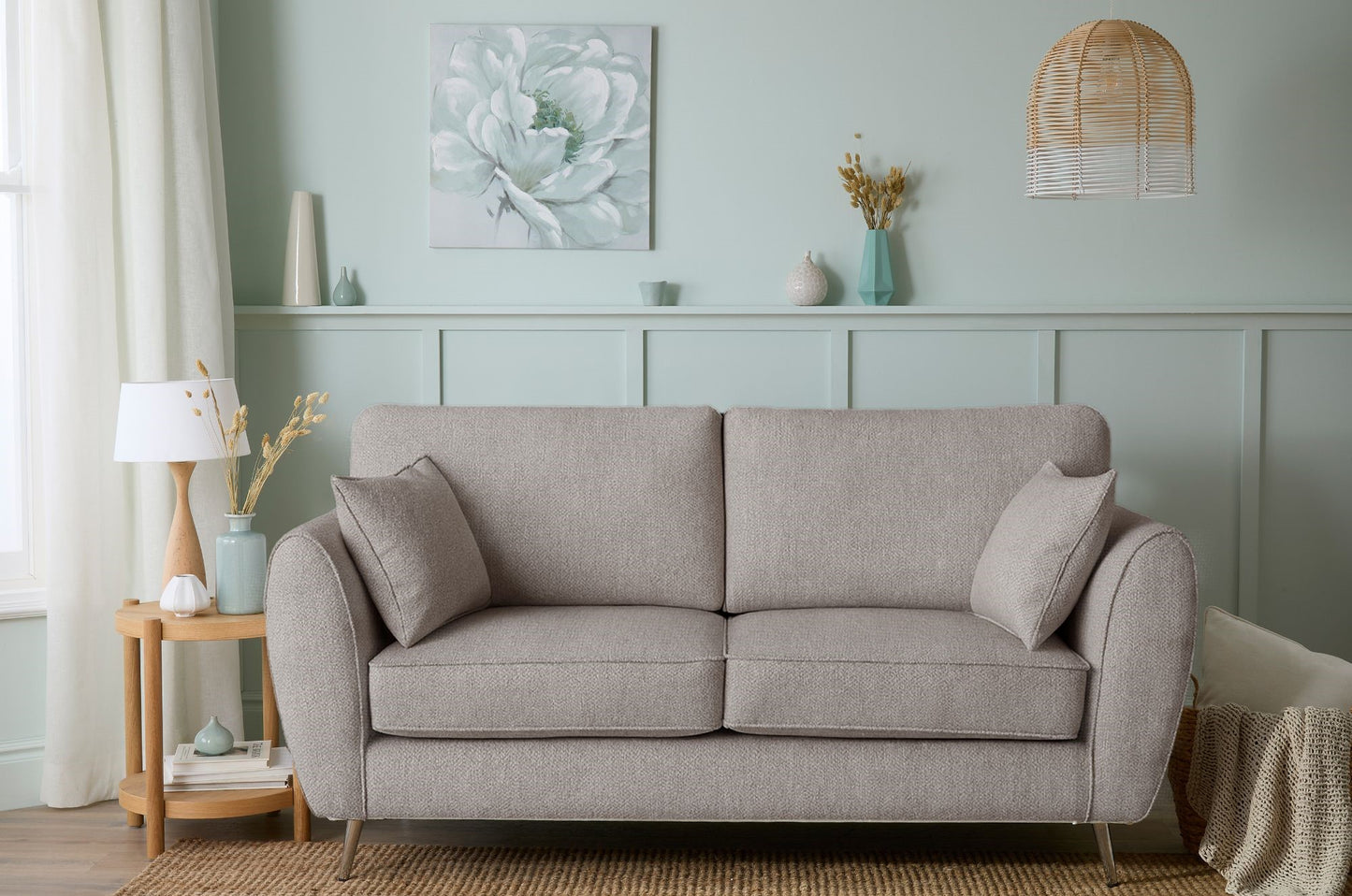 Gray sofa in a living room with decorative elements on a light blue wall.
