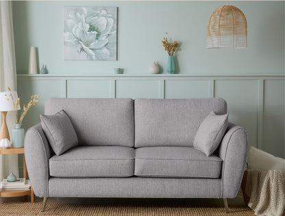 Gray sofa in a living room with decorative elements and a light green wall.