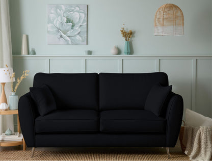 Black sofa in a living room with decorative elements on the wall.
