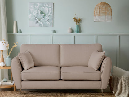 Beige sofa in a living room with decorative elements and a light green wall.