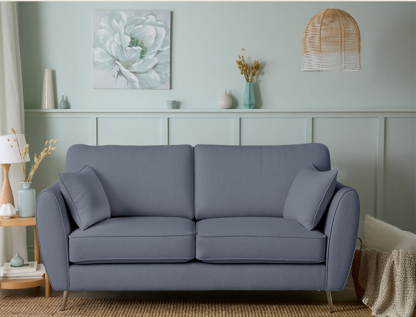 Gray sofa in a living room with decorative elements on a light green wall.