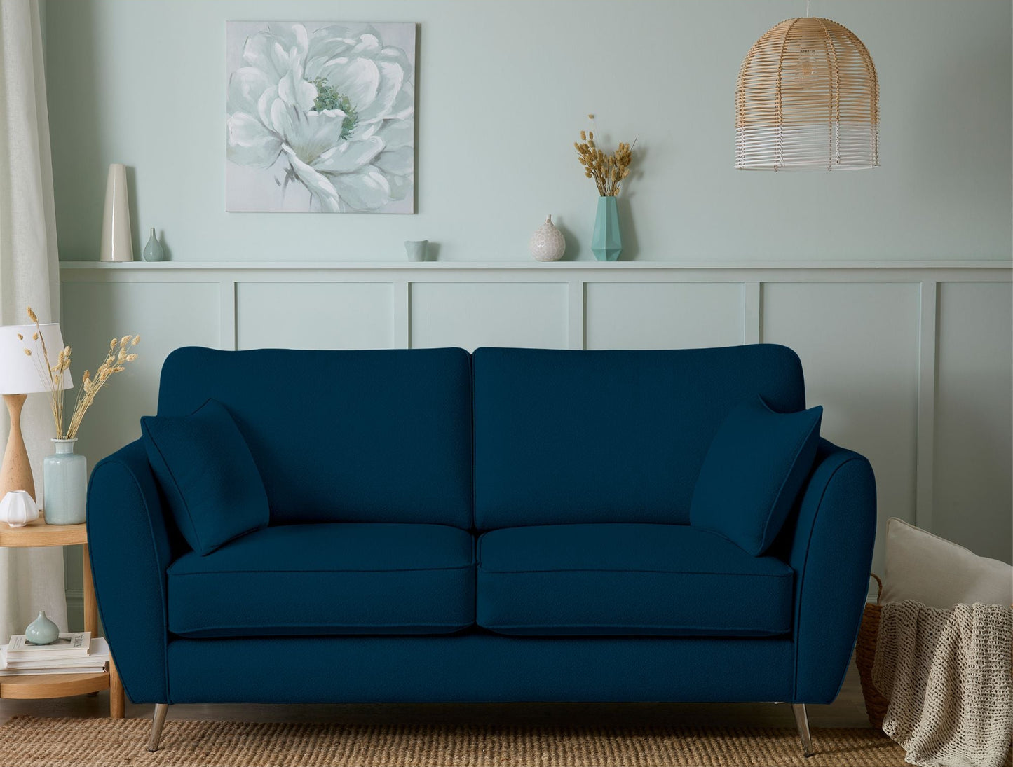 Blue sofa in a living room with decorative elements on a light blue wall.