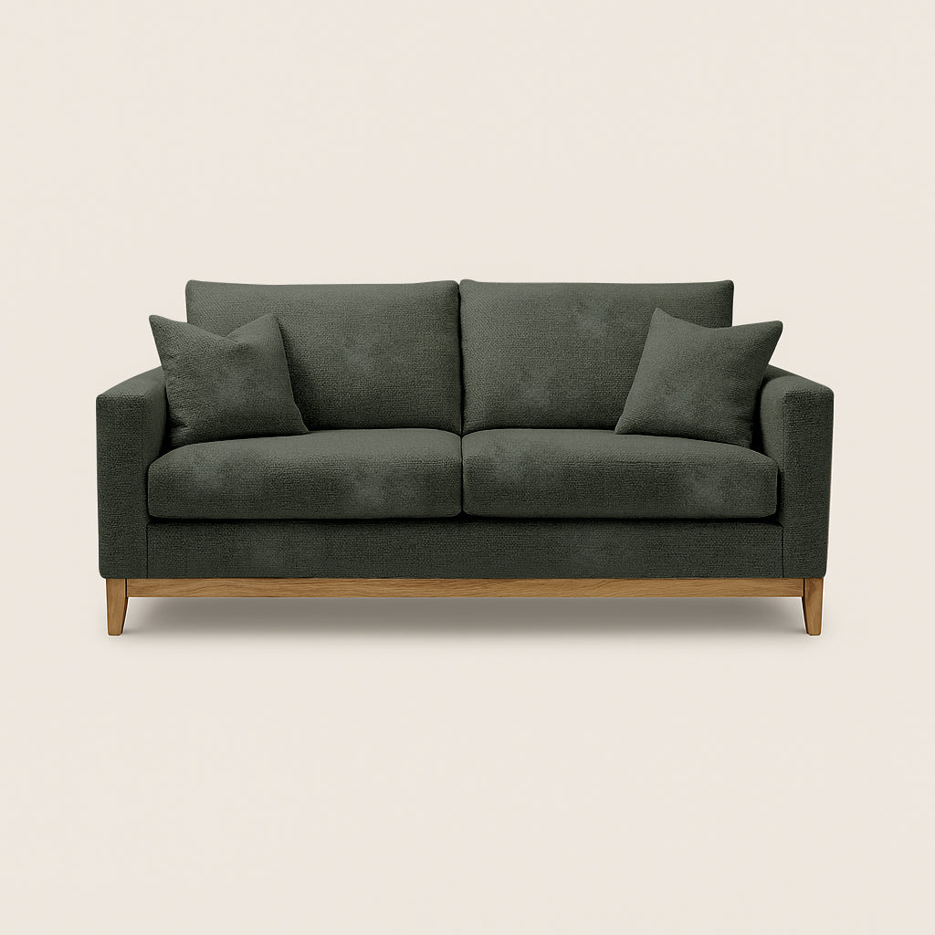 Green sofa with wooden legs on a beige background