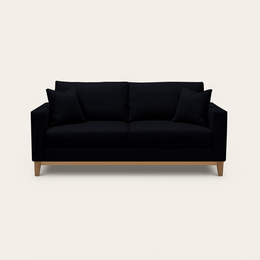 Black sofa with wooden legs on a beige background