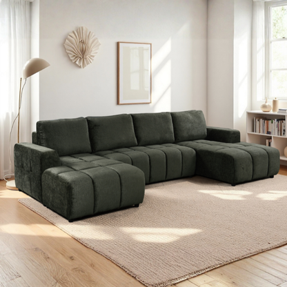 Gray sectional sofa in a living room with a rug and lamp.