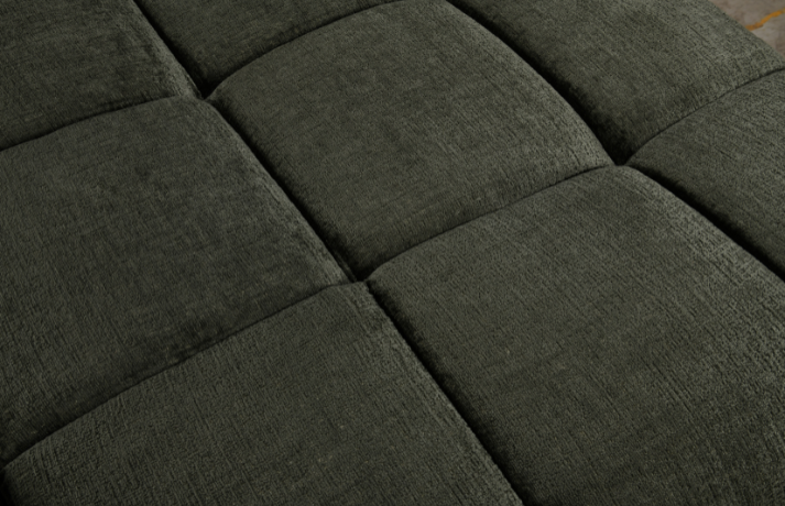 Close-up of a dark green upholstered headboard with tufted design